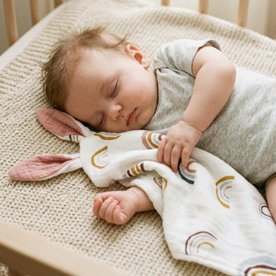 Bébé qui dort avec son doudou oreilles lapin arc-en-ciel coloré en coton mousseline
