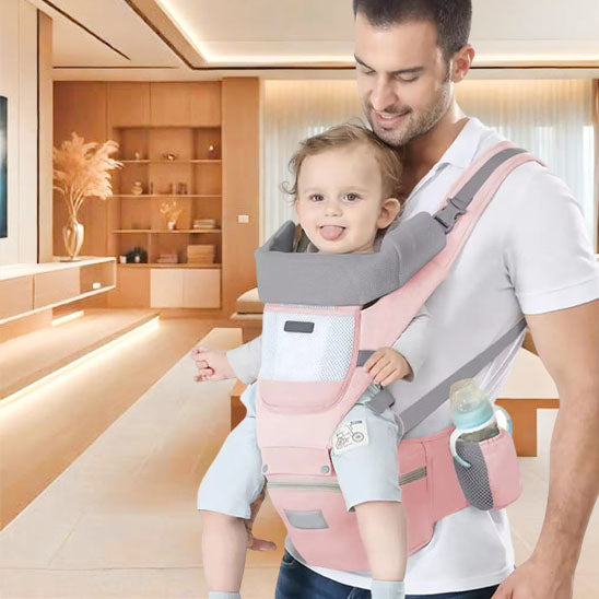 papa porte bebe dans un porte bebe rose gris en avant