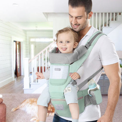 papa porte bebe dans un porte bebe vert moov en avant