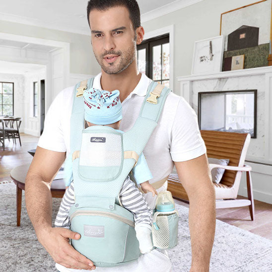 papa porte un nouveau ne dans un porte bebe en avant